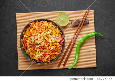 Chinese Bhel in bowl on black table top. Indo-Chinese cuisine street food dish with schezwan sauce Chinese Bhel in bowl on black table top. Indo-Chinese cuisine street food dish with schezwan sauce 66773877