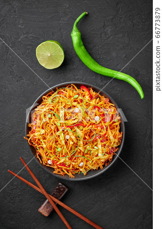 Chinese Bhel in bowl on black table top. Indo-Chinese cuisine street food dish with schezwan sauce Chinese Bhel in bowl on black table top. Indo-Chinese cuisine street food dish with schezwan sauce 66773879