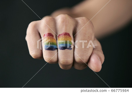 rainbow flag in the fist of a person 66775984