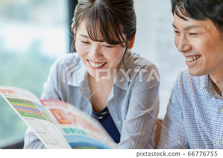 Men and women making plans while looking at travel brochures 66776755