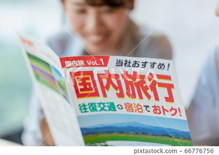 Men and women making plans while looking at travel brochures 66776756