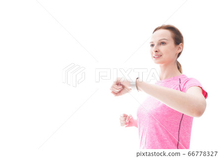 檢查smartwatch的年輕女子穿著運動服 檢查smartwatch的年輕女子穿著運動服 66778327