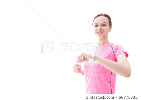 Young woman wearing sportswear checking smartwatch Young woman wearing sportswear checking smartwatch 66778336