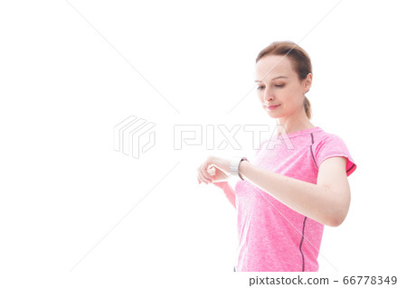 Young woman wearing sportswear checking smartwatch 66778349