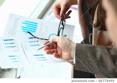 Business colleagues discussing statistics report at work Business colleagues discussing statistics report at work 66778449
