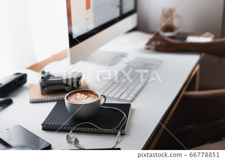 Hot coffee in a cup at the computer desk Hot coffee in a cup at the computer desk 66778851