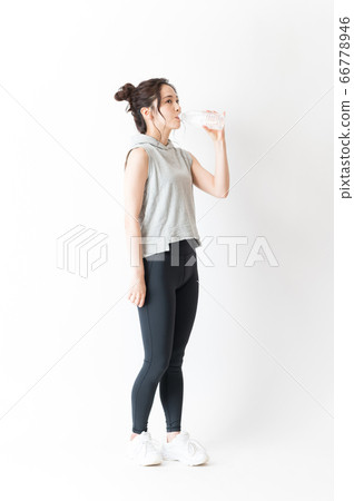 A woman of sportswear drinking water A woman of sportswear drinking water 66778946