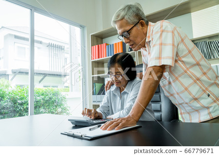 Senior Asian couple using the calculator and Senior Asian couple using the calculator and 66779671