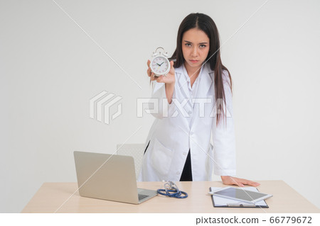 Young female doctor holding a white clock. Concept Young female doctor holding a white clock. Concept 66779672