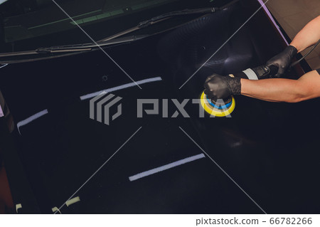 Car detailing - Hands with orbital polisher in auto repair shop. Selective focus. Car detailing - Hands with orbital polisher in auto repair shop. Selective focus. 66782266