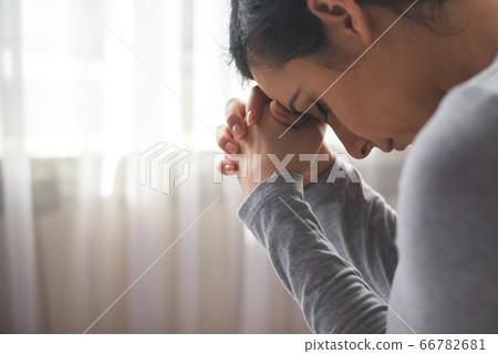 Portrait of woman praying 66782681