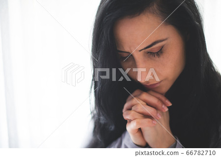 Portrait of woman praying 66782710