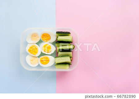 Eggs and cucumber in a container. Healthy eating concept. Flat lay Eggs and cucumber in a container. Healthy eating concept. Flat lay 66782890