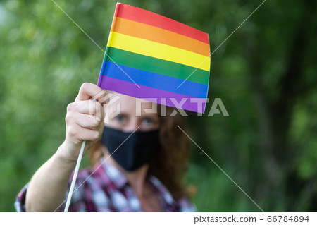 woman with mask holding rainbow flag   LGBT rights 66784894