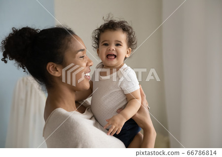 Smiling loving African American woman holding cute toddler daughter 66786814
