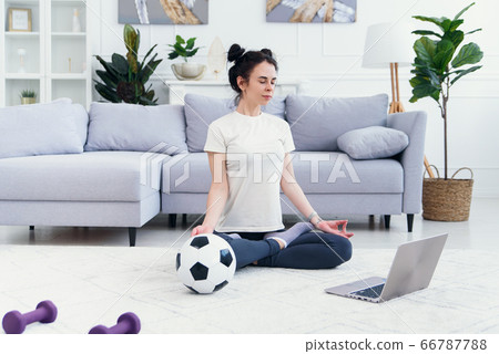 Mother and daughter practicing online yoga lesson at home at quarantine isolation period during coronavirus pandemic. Family doing sport together online from home. Healthy lifestyle 66787788