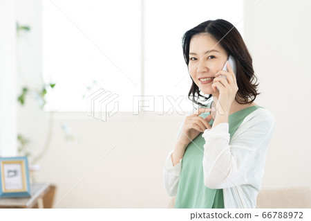 A middle woman who calls on a smartphone [Living] 66788972