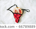 Sexy Grapefruit in red women's panties on a soft white bed 66789889