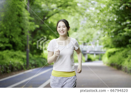 慢跑以新鮮綠色的年輕女子 慢跑以新鮮綠色的年輕女子 66794820
