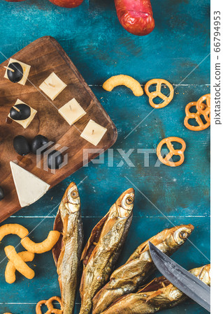 Dried fish snacks on the blue background with pretzel crackers, top view Dried fish snacks on the blue background with pretzel crackers, top view 66794953