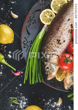 Fish with herbs and vegetables served with lemon Fish with herbs and vegetables served with lemon 66795543