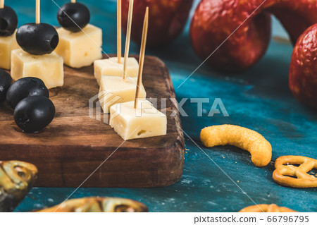 Cheese cubes with black olives and other snacks 66796795