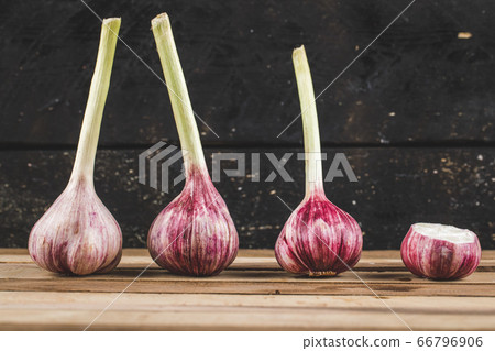 Red garlic gloves on the wooden table in a row Red garlic gloves on the wooden table in a row 66796906