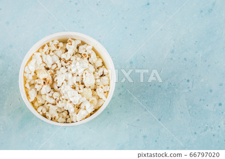 Popcorns in a yellow box on blue table, top view 66797020