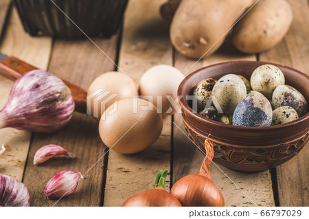 Eggs, garlic and onions on a wooden board Eggs, garlic and onions on a wooden board 66797029