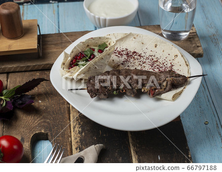 Meat barbecue served with lavash bread on the blue table on a wooden board 66797188