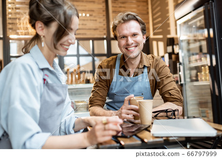 Couple of a cheerful cafe workers indoors 66797999