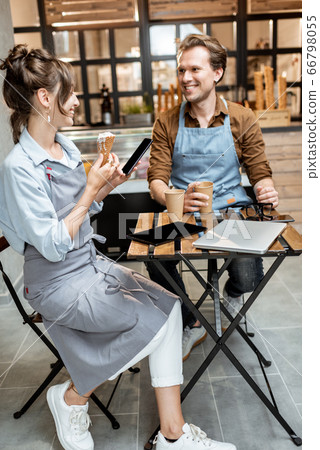 Couple of a cheerful cafe workers indoors Couple of a cheerful cafe workers indoors 66798055