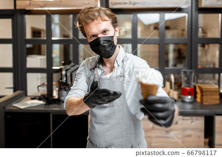 Ice cream seller in protective mask and gloves in a shop Ice cream seller in protective mask and gloves in a shop 66798117