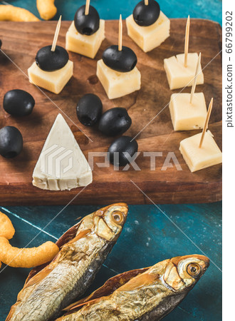 Snack board with cheese cubes and dry fish 66799202