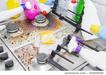 dirty kitchen stove, empty and full bottles of detergents around. dirty kitchen stove, empty and full bottles of detergents around. 66800098