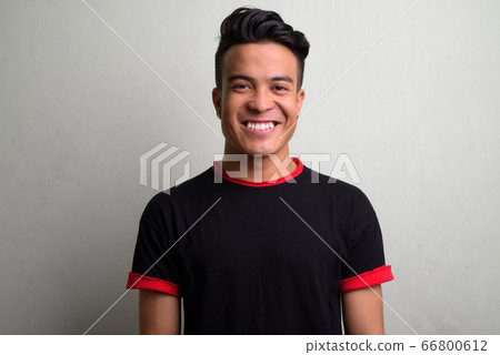 Young multi-ethnic man wearing black shirt against white background 66800612