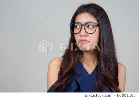 Face of stressed young Asian businesswoman looking annoyed Face of stressed young Asian businesswoman looking annoyed 66801105