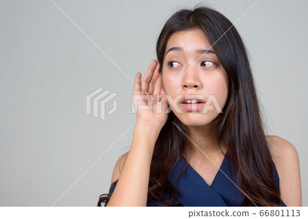 Face of young beautiful Asian businesswoman thinking and listening Face of young beautiful Asian businesswoman thinking and listening 66801113