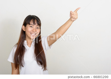 Portrait of happy young Asian woman pointing finger 66801200