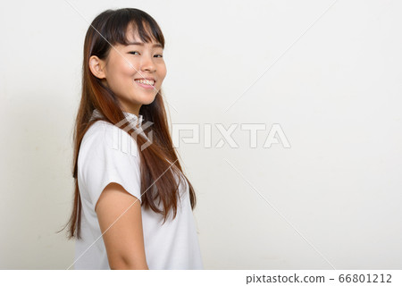 Profile view of happy young Asian woman looking at camera 66801212