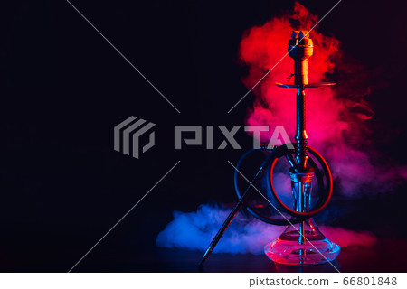 hookah with a glass flask and a metal bowl shisha with colored smoke on the table hookah with a glass flask and a metal bowl shisha with colored smoke on the table 66801848