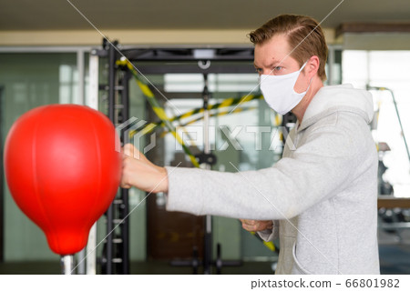 Young man wearing mask and boxing at the gym 66801982