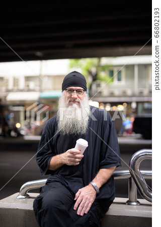 Mature bearded hipster man with paper cup in the city Mature bearded hipster man with paper cup in the city 66802193