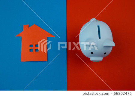 Mortgage concept. Little paper house next to a piggy bank on colorful background Mortgage concept. Little paper house next to a piggy bank on colorful background 66802475