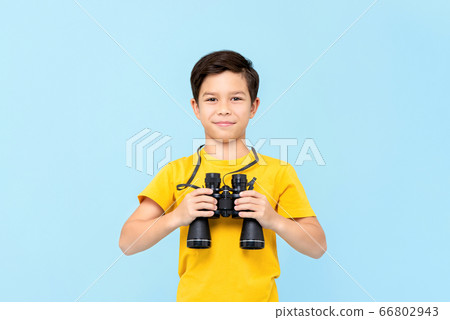Portrait of smiling young boy holding binocular 66802943