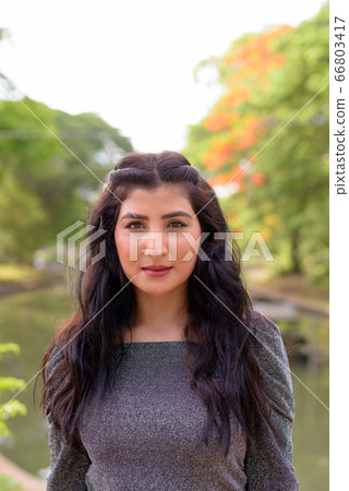 Face of young beautiful Indian woman at the park outdoors 66803417