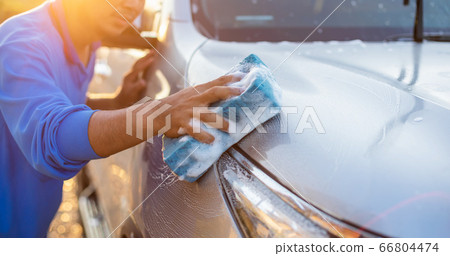 Asian man using blue sponge with soap to washing 66804474