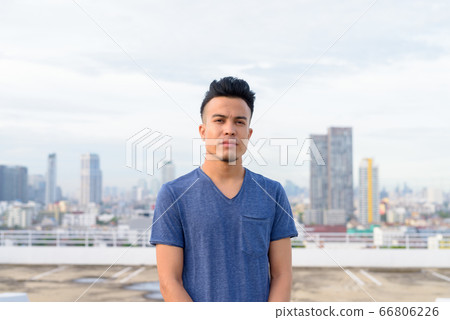 Young handsome multi ethnic man against view of the city Young handsome multi ethnic man against view of the city 66806226