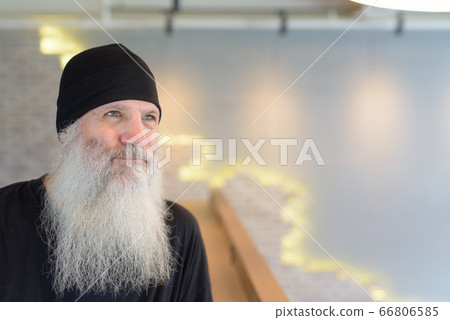 Face of mature handsome bearded hipster man thinking indoors 66806585