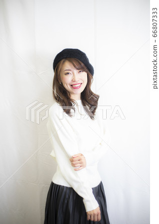 Smiling young woman indoor hat black and white 66807333